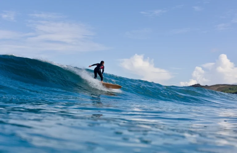 surfende vrouw tijdens surf yoga retreat in Spanje