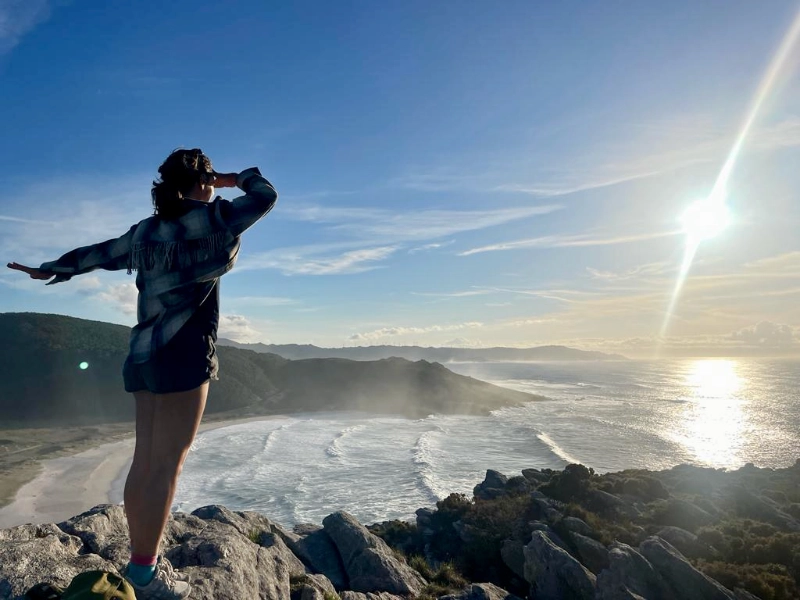 vrouw kijkt uit over de zee tijdens een surf en yoga retreat in Spanje