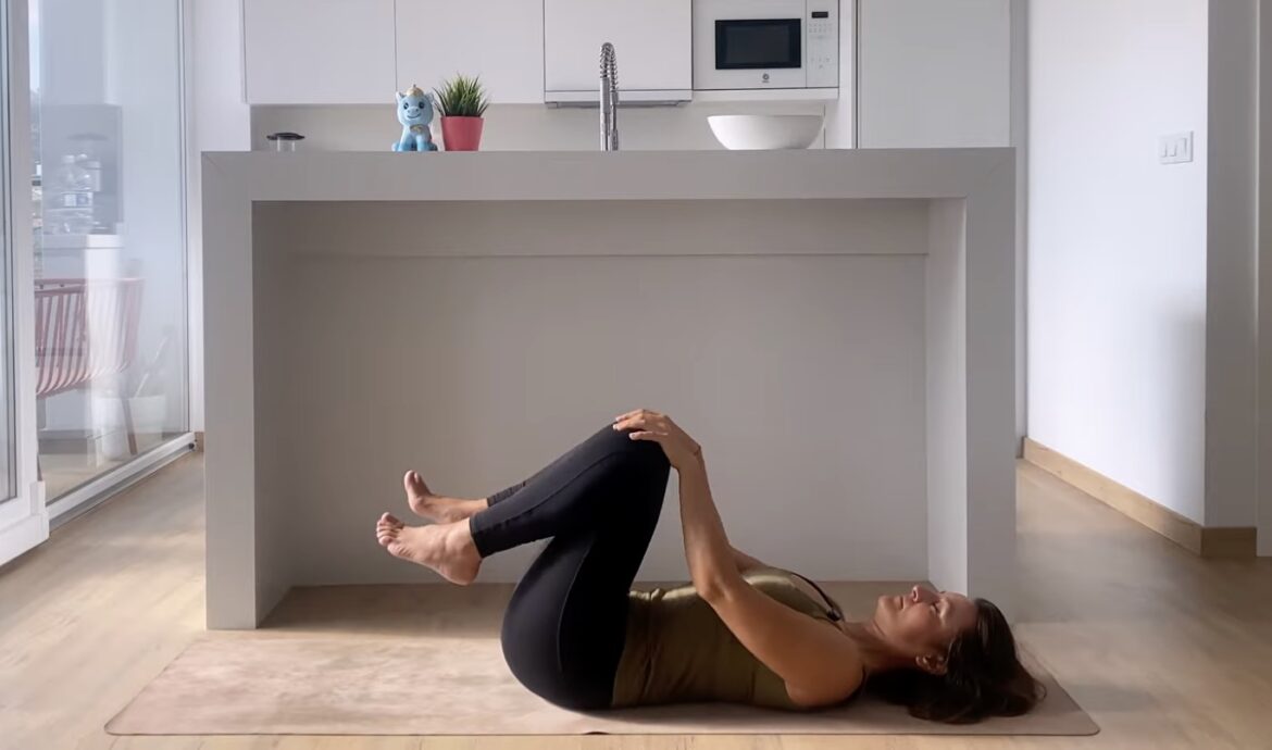 vrouw die yoga in bed doet om haar menstruatiepijn te verminderen