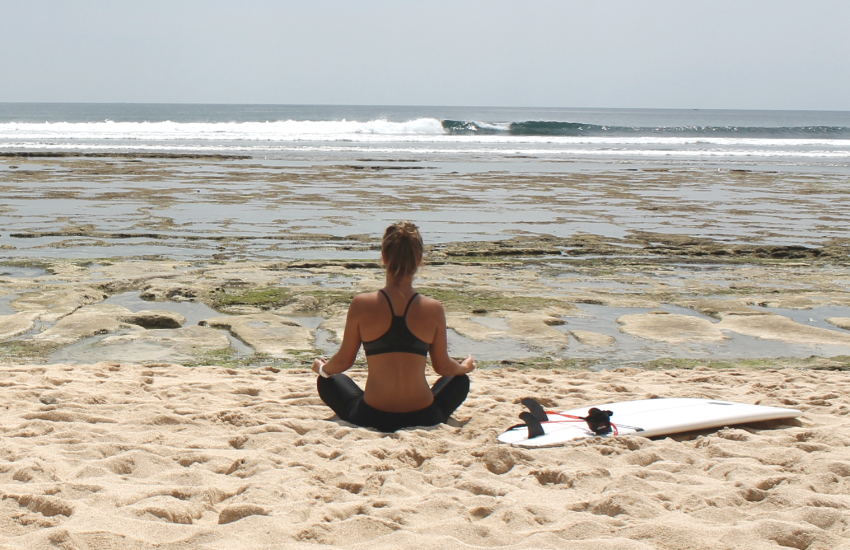 vrouw die yoga voor surfers doet op het strand en mediteert