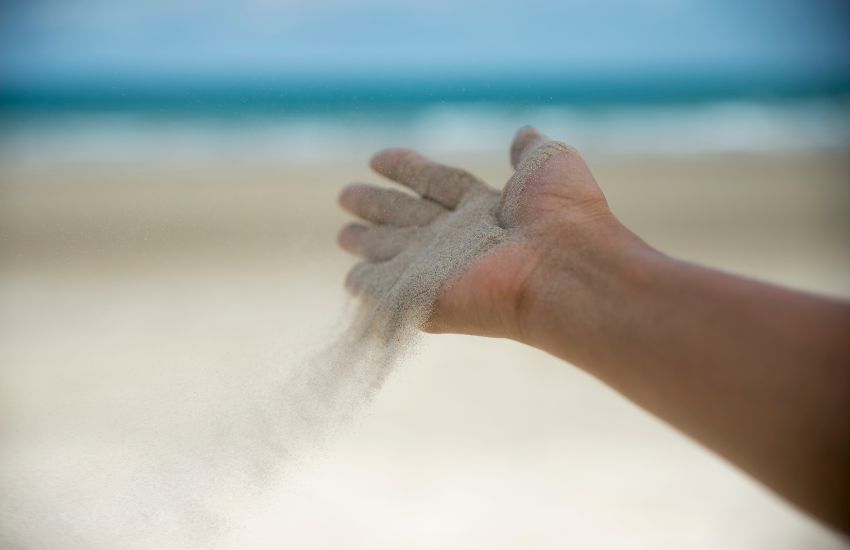 zand uit hand om loslaten door yin yoga voor te stellen